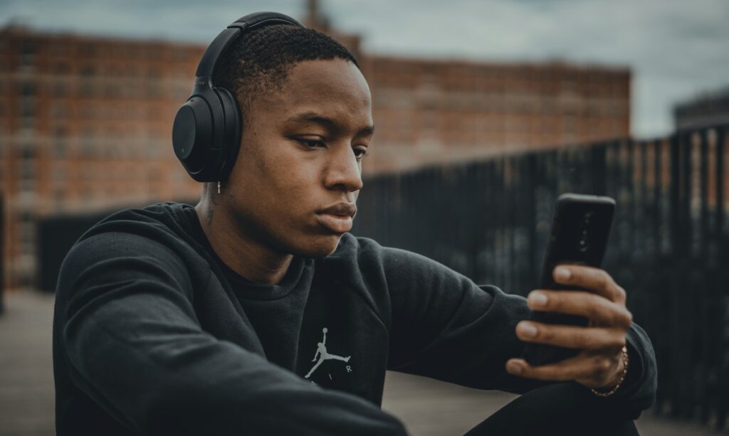 Homem ouvindo música com fones e smartphone