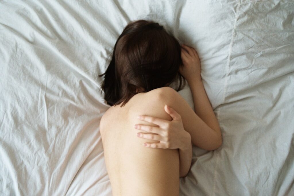 Mulher deitada na cama, contexto de tontura ao deitar ou virar a cabeça