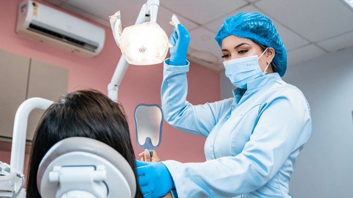 Profissional de odontologia avaliando a boca de paciente