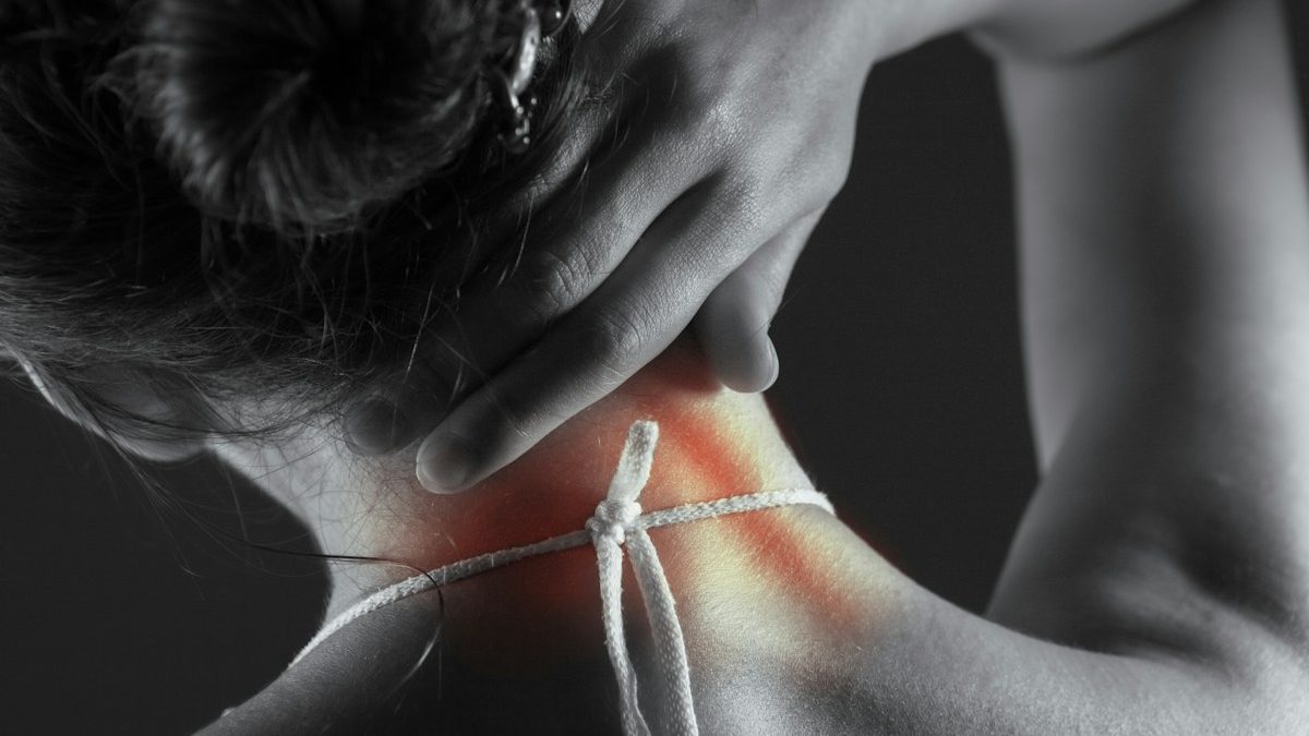 Mulher com dor na região cervical, contexto da relação entre pescoço e zumbido