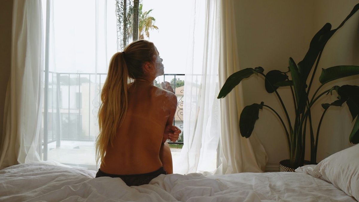 Mulher sentada na beirada da cama ao despertar, contexto do artigo sobre tontura ao levantar