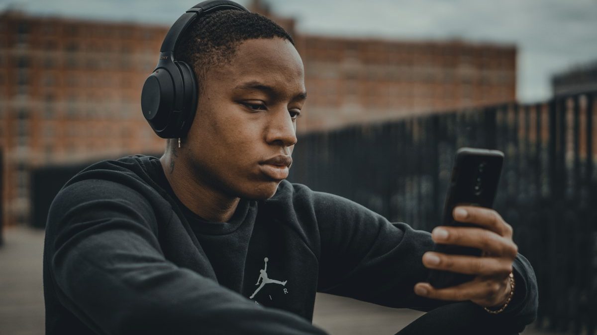 Homem ouvindo música com fones e smartphone