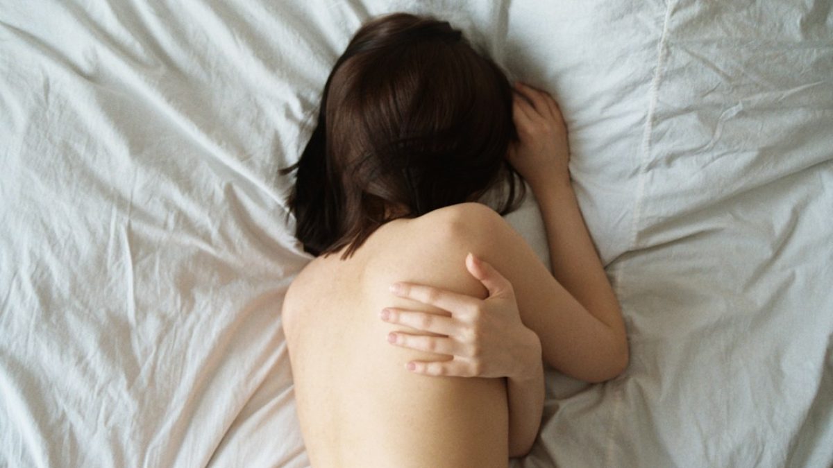 Mulher deitada na cama, contexto de tontura ao deitar ou virar a cabeça