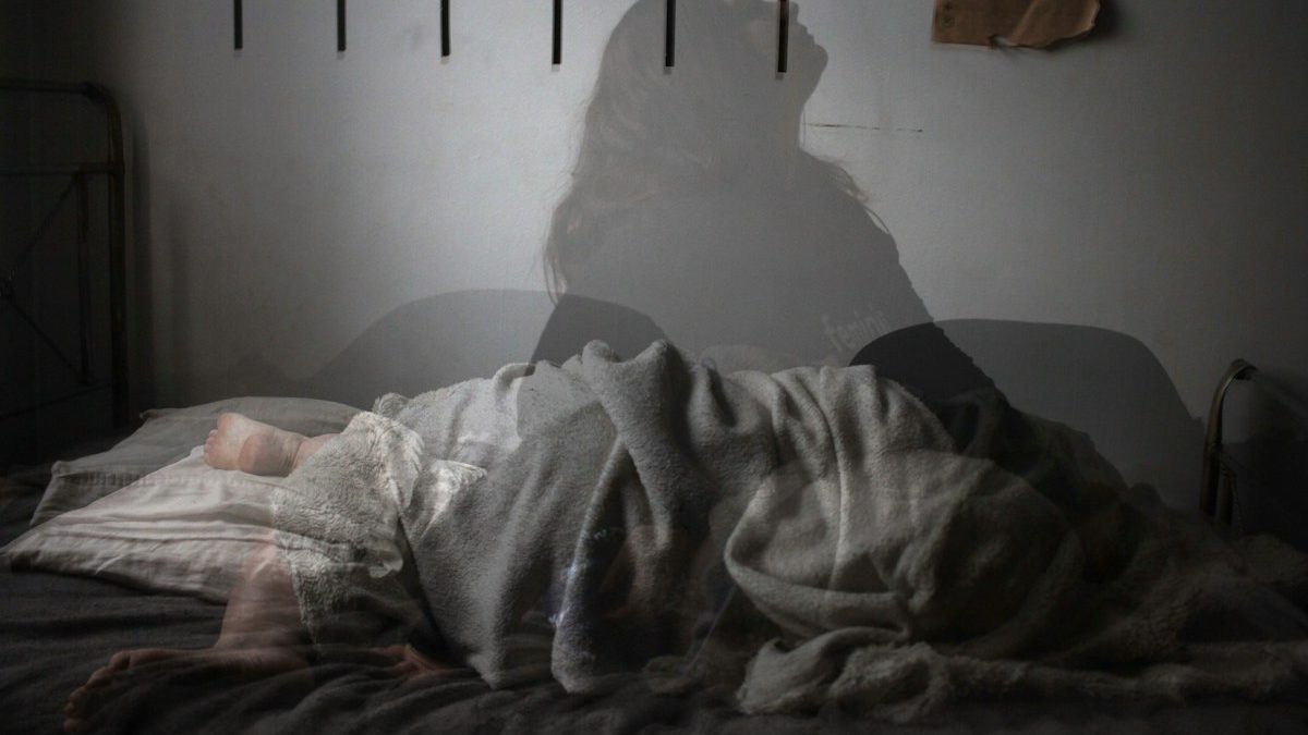 Pessoa acordada à noite em contexto de dificuldade para dormir